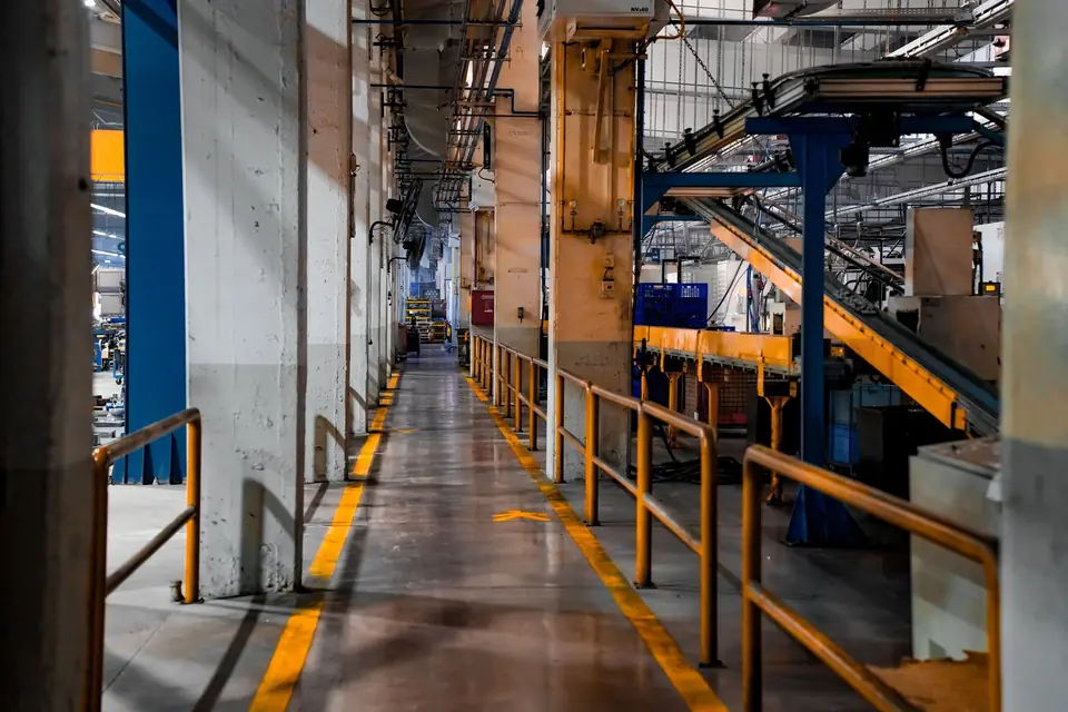 Factory walkway with yellow safety markings and conveyors