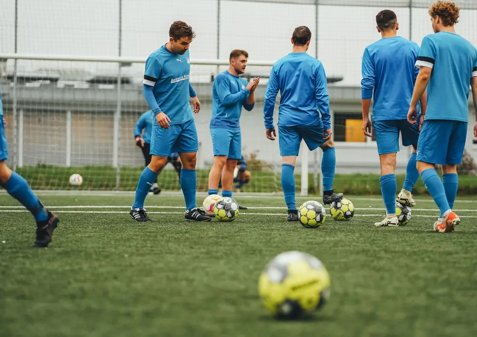 Footballers in blue training kit on a pitch