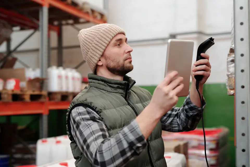 Warehouse worker scanning stock with a handheld scanner and tablet